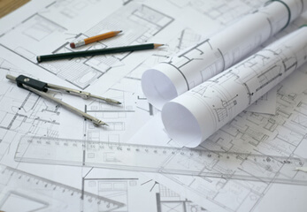 Zeichnungen, Pläne und Karten digitalisieren Architekturzeichnungen liegen auf einem Tisch